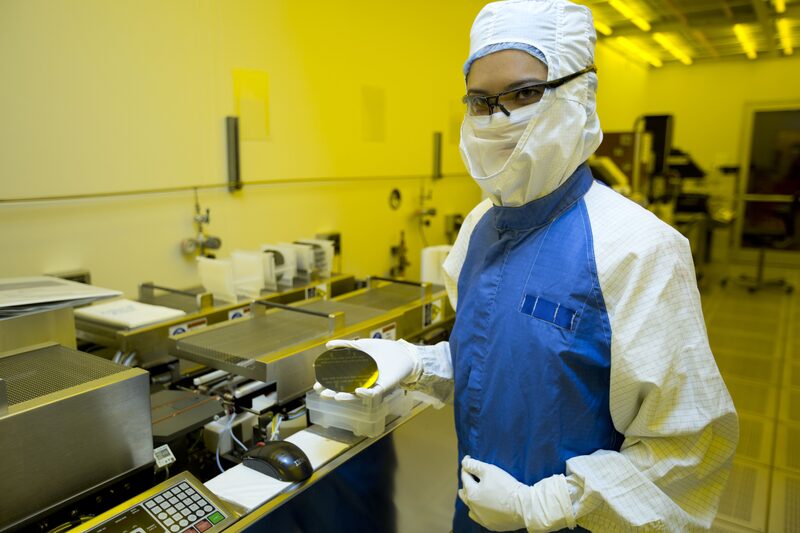 Several computer processors and a small electronic component placed on a blue hexagon patterned surface.